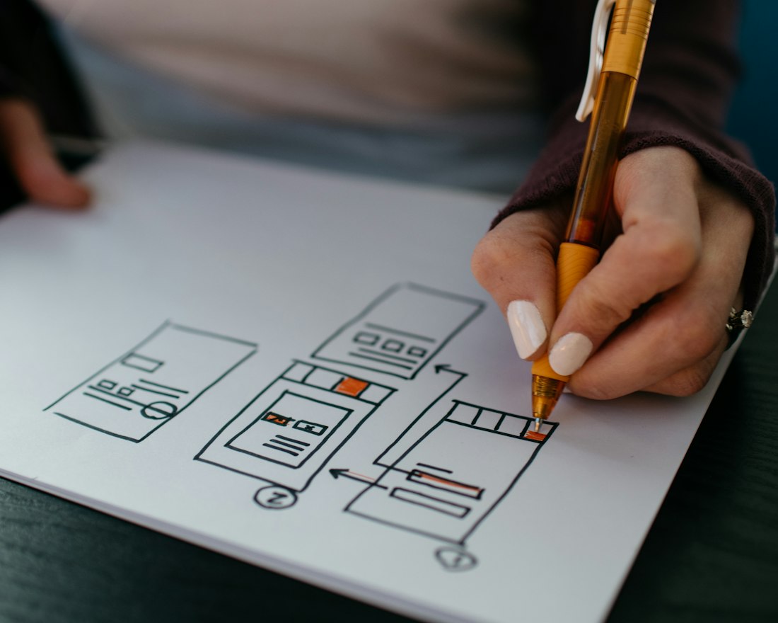 Hand sketching an app wireframe on paper