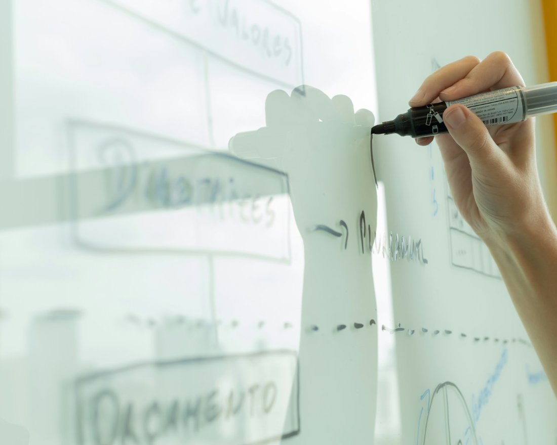 Hand drawing a systems diagram on a whiteboard